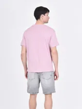 Remera rosa viejo de corte recto y cuello redondo, con estampado frontal que incluye la frase "Sorry But I Don't Care" y otros textos.