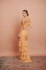 Vestido largo color durazno, entallado, con escote en V, breteles finos, drapeado en el frente y falda con volados.