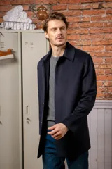 Chaquetón clásico de lana color negro, con cuello camisero, cierre frontal de botones y corte recto.