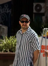 Camisa oversize unisex de lino con spandex a rayas verticales blancas y verdes, con cuello clásico y mangas cortas. Corte amplio y largo a la cadera.