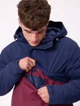 Campera tipo canguro con capucha, diseño color block en azul marino y bordó. Cuenta con cierre frontal parcial, bolsillos laterales y logo de la marca bordado en el pecho.