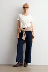 Jean culotte de tiro alto y corte recto, confeccionado en denim de color azul oscuro. Presenta costuras en contraste y un diseño de pierna ancha con ruedo desflecado.