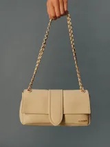 Cartera de cuero de cordero color blanco de silueta rectangular, con solapa frontal, cierre magnético y correa de cadena combinada con cuero trenzado. Incluye el logotipo de la marca grabado en dorado en el frente.