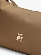 Cartera crossover Tommy Hilfiger de nailon brillante en color marrón. Presenta un diseño versátil con asa superior corta y correa cruzada extraíble, cierre de cremallera y el monograma TH metálico en la parte frontal.