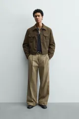 Cazadora cropped fit de efecto piel en color verde militar, con cuello solapa, manga larga con puño abotonado, bolsillos frontales de plastrón con solapa y cierre de botonadura.