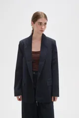 Blazer de corte holgado con diseño de rayas verticales, cuello solapa y cierre frontal con un botón. Cuenta con bolsillos laterales con solapa.
