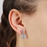 Aros colgantes plateados con forma circular y pequeños cristales incrustados.