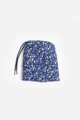 Short de baño celeste con estampado de hojas pequeñas en tonos verdes y blancos. Cuenta con cintura elástica con cordón ajustable, bolsillos laterales y un parche circular con logo en la parte inferior.