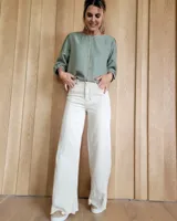 Jean de corte ancho y tiro alto, confeccionado en denim 100% algodón. Presenta costuras verticales decorativas en el frente, bolsillos laterales y ruedo desflecado.