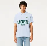 Remera polo de piqué de algodón orgánico color celeste con cuello y mangas acanaladas, cierre frontal con botones de nácar y estampa frontal de la marca con diseño tipográfico en verde. Cuenta con el clásico cocodrilo bordado en el pecho.