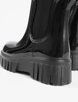 Botas de lluvia tipo chelsea con acabado brillante, suela track robusta y paneles laterales elásticos a tono.