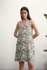 Vestido corto con estampado abstracto en tonos grises y blancos, escote en V y sin mangas.
