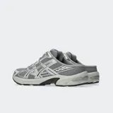 Championes Asics modelo Gel 1130 Mule, de diseño estilo zapatilla sin talón (mule), color gris y plateado, confeccionados con malla transpirable y detalles superpuestos.