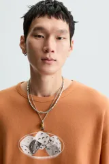 Camiseta boxy fit de punto tejido en hilatura de algodón, color terracota, con cuello redondo y manga corta. Estampado frontal de dados en tonos grises y blancos dentro de un óvalo.