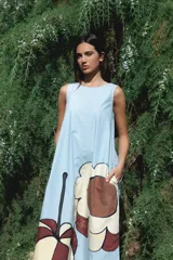 Vestido largo sin mangas de corte holgado, con cuello redondo y bolsillos laterales. Confeccionado en algodón, presenta un diseño minimalista y fluido.