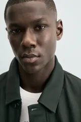 Cazadora relaxed fit color verde oscuro, confeccionada en tejido de algodón. Cuenta con cuello solapa, manga larga con puño abotonado, bolsillos plastrón con solapa en la cadera y cierre frontal de botonadura.