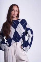 Sweater con diseño de rombos azul marino y gris claro, de tejido de punto, mangas largas y corte holgado.