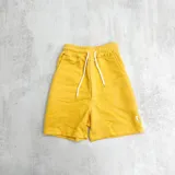 Short deportivo amarillo con cintura elástica ajustable con cordón, bolsillos laterales y logo bordado en blanco.