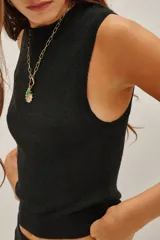 Top sin mangas con cuello halter, confeccionado en tejido de punto con acabado metalizado. Presenta un ajuste al cuerpo y diseño minimalista.