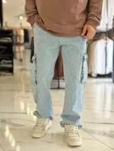 Pantalón de jean cargo color azul, con bolsillos laterales con solapa en los muslos, corte recto y holgado.