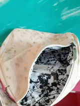Mochila de cuero natural con efecto desgastado, diseño pintado a mano de Carolina De Cunto, correa ajustable en negro con inscripciones y cierre de cremallera.