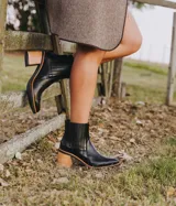 Bota corta de cuero vacuno color negro, con elástico lateral, taco de madera y punta fina.