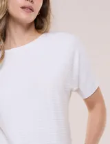 Buzo tejido de punto fino Allie Rose, de color blanco, con sutil textura acanalada horizontal, escote redondo amplio, manga corta holgada con caída y silueta relajada.