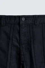 Pantalón de corte recto, color azul marino, confeccionado en tejido jacquard con textura de rayas verticales en relieve. Presenta cierre frontal con botón y bolsillos laterales y traseros de vivo.