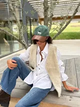 Gorra tipo polo con cuerpo de tela verde y visera de cuero marrón, con un caballo bordado en el frente.