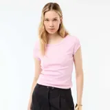 Camiseta de manga corta y cuello redondo, confeccionada en tejido de punto canalé de color rosado con ajuste al cuerpo.