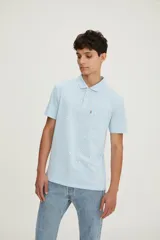 Polo de manga corta Levi's en color celeste, con estampado de pequeños pájaros en toda la prenda. Presenta cuello clásico, cierre de tres botones, bolsillo frontal en el pecho con etiqueta roja distintiva de la marca y calce estándar.