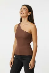 Top de algodón con elastano, de diseño asimétrico con un solo hombro y detalle de tachas metálicas a lo largo del escote. Presenta un corte ajustado al cuerpo y textura acanalada.