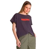 Remera de corte relajado y silueta fluida, color gris oscuro, con cuello redondo y mangas cortas. Presenta un estampado gráfico con el logo de la marca en color naranja en el pecho.
