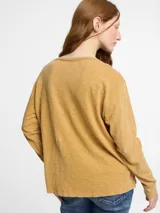 Remera de manga larga color beige, con escote en V y bolsillo en el pecho.