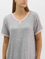 Camisón corto de corte recto y textura acanalada, color azul marino con estampado floreado en tonos celestes y blancos. Presenta mangas cortas y escote en V con aplicación de pequeños botones.