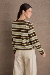 Buzo de algodón a rayas horizontales en tonos chocolate, crema y amarillo, con cuello redondo y puños acanalados. Presenta un pequeño bordado con la palabra Savia en el centro del pecho.