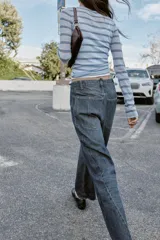 Jeans de tiro alto con corte balloon y pernera holgada. Presenta diseño de cinco bolsillos, cierre frontal con cremallera y botón, y detalle de costuras marcadas en el delantero y la espalda.