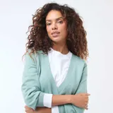 Sweater de punto color verde menta con diseño cruzado tipo cárdigan, escote en V y puños acanalados.