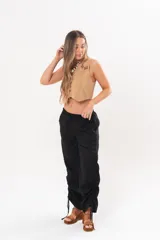 Pantalón holgado negro de lino con cintura elastizada y cordones ajustables en los laterales de las piernas.