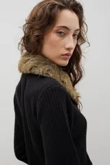 Saco tejido de algodón en color negro, con cierre frontal y detalles de piel sintética en cuello y puños.