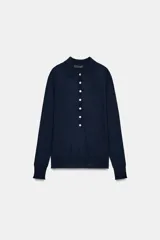 Jersey polo de punto fino color verde lima, confeccionado con lana. Presenta cuello polo, manga larga y botones delanteros.