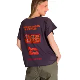 Remera de corte relajado y silueta fluida, color gris oscuro, con cuello redondo y mangas cortas. Presenta un estampado gráfico con el logo de la marca en color naranja en el pecho.