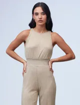 Enterito largo de gasa lurex plisada color dorado, con escote halter, cintura elastizada con punto smock, abertura en la espalda con cierre invisible y forro interno a tono.