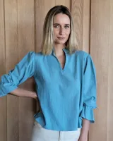 Blusa de algodón color azul, con cuello mao y escote en V, mangas tres cuartos con terminación en volado y diseño holgado.