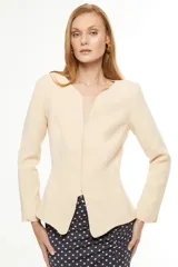 Blazer color arena con escote en V, corte entallado y mangas largas.