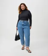 Pantalón mom jeans de tiro alto y corte holgado en caderas y piernas, con bolsillos, presillas para cinturón y cierre frontal con botón.