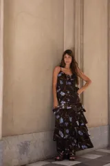 Conjunto de dos piezas compuesto por un top de tirantes finos con volados en el escote y una falda larga de corte evasé con volados en capas. Presenta un estampado floral en tonos azules sobre fondo oscuro.