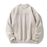 Buzo oversize color beige de tela suave con textura similar a gamuza, cuello redondo y diseño con estampado frontal con texto "Magisterial Master The Youth".