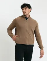 Cardigan de punto color marrón, con cuello alto y cierre frontal completo. Presenta mangas largas tipo ranglan y bolsillos laterales de ribete.