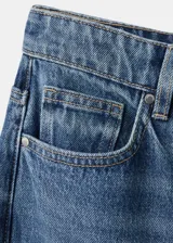 Jeans de denim azul de tiro medio y diseño wide leg largo, con cinco bolsillos, trabillas para cinto y cierre de botón y cremallera.